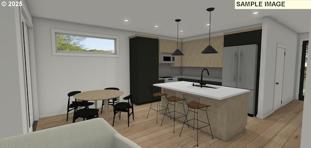 kitchen with a kitchen breakfast bar, white appliances, sink, pendant lighting, and an island with sink