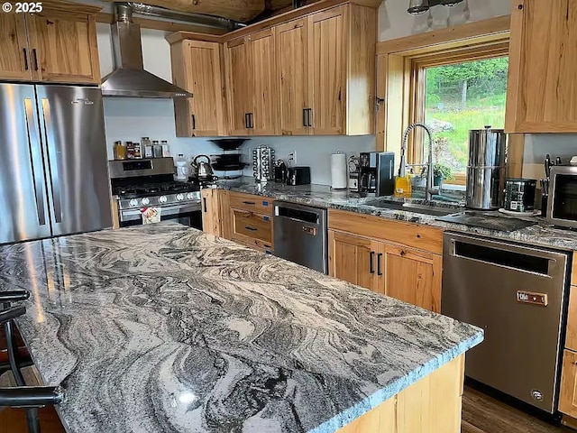 55778 SW Scoggins Valley Rd, Gaston, OR 97119 - kitchen with wall chimney range hood, stainless steel appliances, a sink, dark stone countertops, and a breakfast bar area