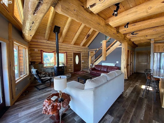 55778 SW Scoggins Valley Rd, Gaston, OR 97119 - living room with log walls, wooden ceiling with exposed beams, dark wood-type flooring, a wood stove, and stairway