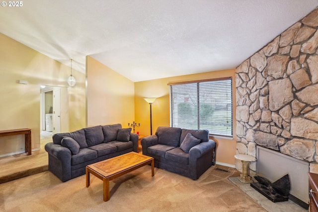 living room featuring washer / clothes dryer, a fireplace, light colored carpet, and vaulted ceiling