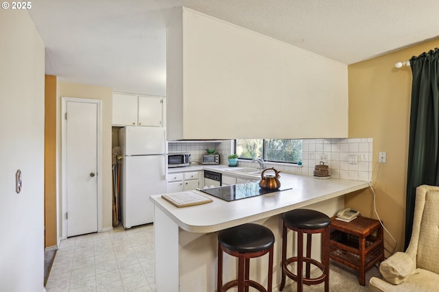 kitchen featuring white cabinetry, sink, stainless steel appliances, and kitchen peninsula