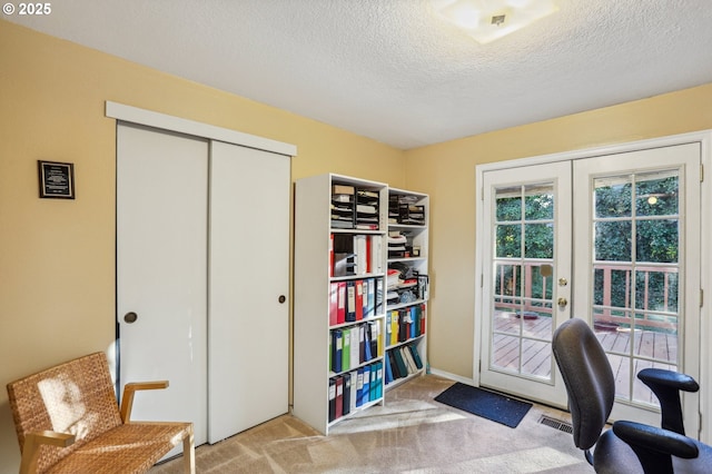 office space featuring light carpet, french doors, and a textured ceiling