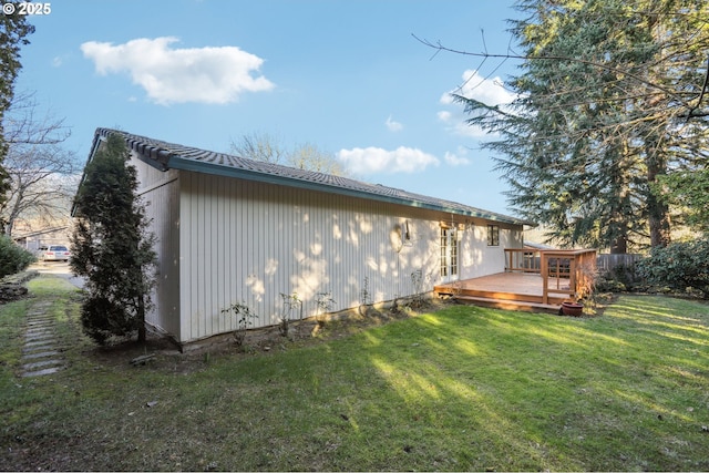 view of property exterior featuring a wooden deck and a lawn