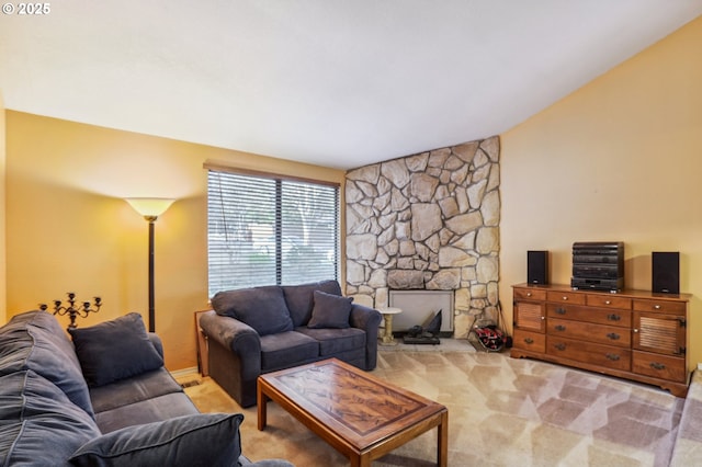 carpeted living room featuring a stone fireplace and vaulted ceiling