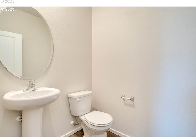 bathroom with hardwood / wood-style flooring and toilet