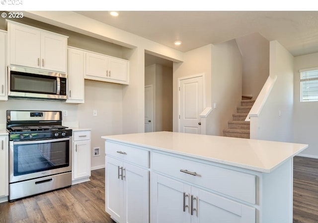 kitchen featuring appliances with stainless steel finishes, light wood-type flooring, a kitchen island, and white cabinets