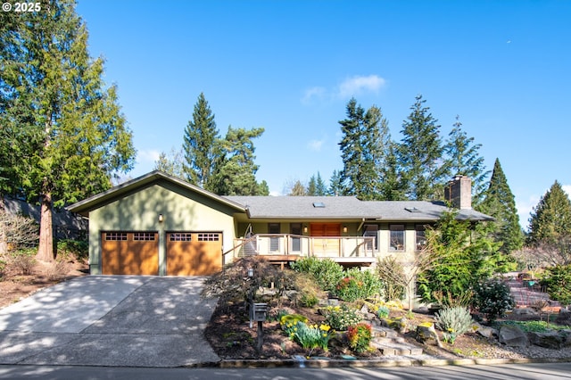 ranch-style house featuring driveway, a chimney, and an attached garage