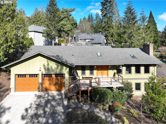 view of front facade featuring a chimney, driveway, roof with shingles, and an attached garage