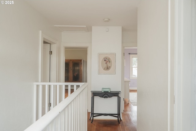 corridor featuring attic access and dark wood finished floors