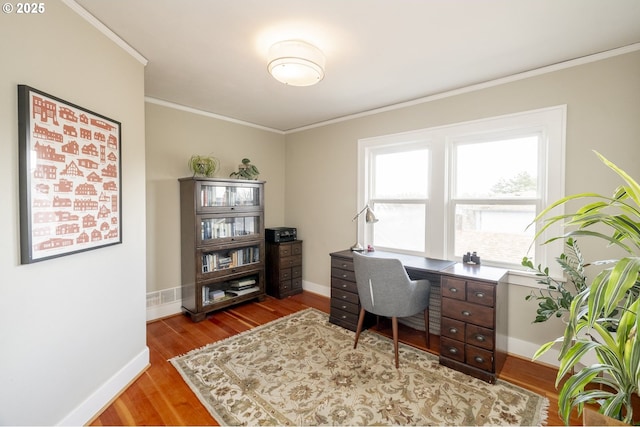 office area featuring visible vents, wood finished floors, baseboards, and ornamental molding