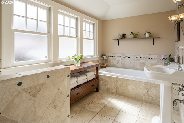 bathroom with tile patterned floors, lofted ceiling, and a bath