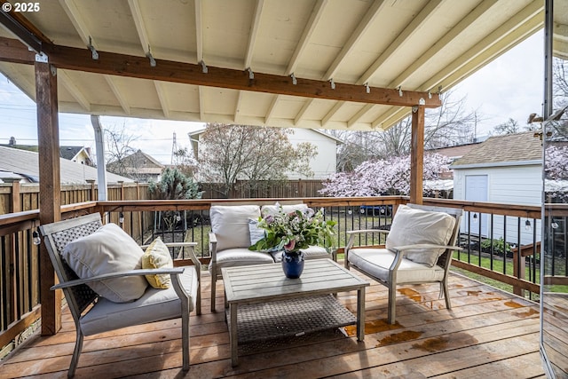 wooden terrace with an outdoor living space and fence