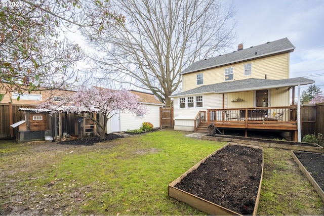 back of house with a garden, a lawn, roof with shingles, and a fenced backyard