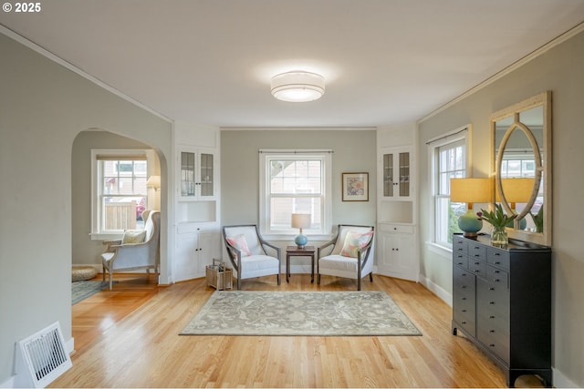 sitting room with plenty of natural light, visible vents, and light wood-type flooring