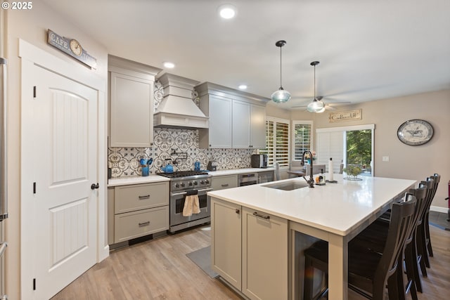 24150 NW Green Mountain Rd, Banks, OR 97106 - kitchen with stainless steel stove, custom exhaust hood, a sink, gray cabinetry, and ceiling fan
