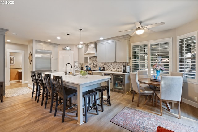 24150 NW Green Mountain Rd, Banks, OR 97106 - kitchen with custom exhaust hood, stainless steel built in fridge, a ceiling fan, tasteful backsplash, and a breakfast bar area