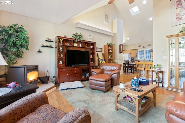 24150 NW Green Mountain Rd, Banks, OR 97106 - living room with a skylight, light wood-style floors, high vaulted ceiling, a ceiling fan, and a wood stove