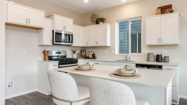 kitchen with stainless steel appliances, light countertops, white cabinets, and a sink