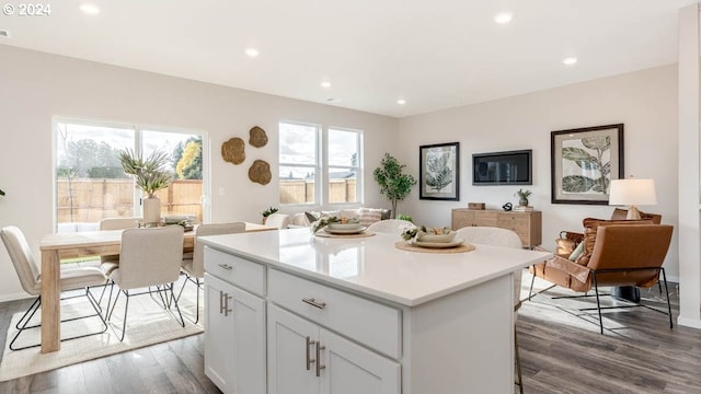 kitchen with recessed lighting, light countertops, dark wood-type flooring, open floor plan, and a kitchen island