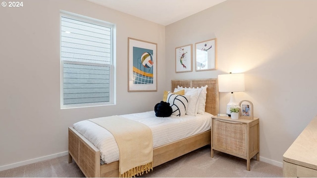 bedroom featuring baseboards and light colored carpet