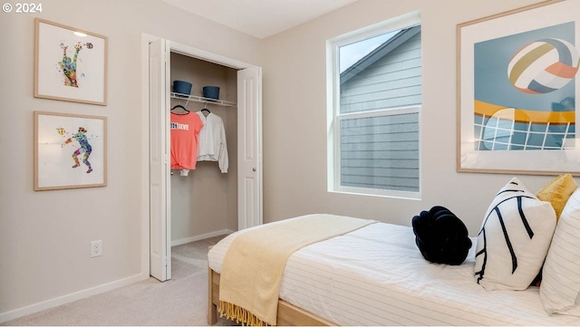 carpeted bedroom featuring a closet and baseboards