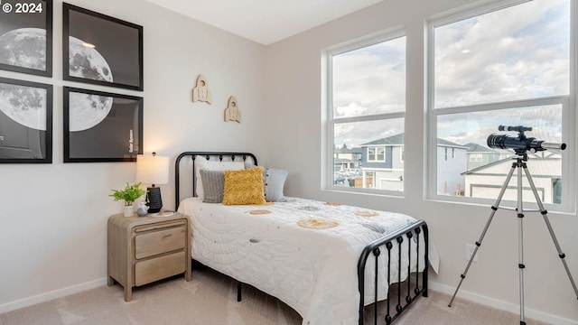 carpeted bedroom featuring multiple windows and baseboards