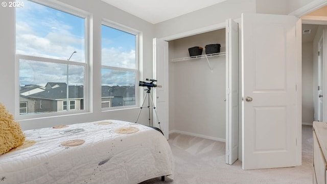 carpeted bedroom with a closet and baseboards