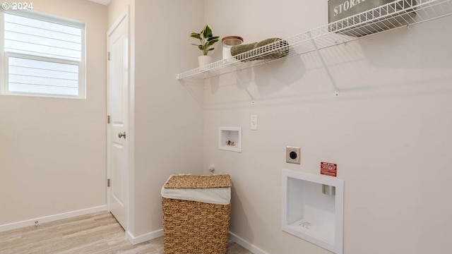 clothes washing area with hookup for a washing machine, light wood-style flooring, electric dryer hookup, laundry area, and baseboards