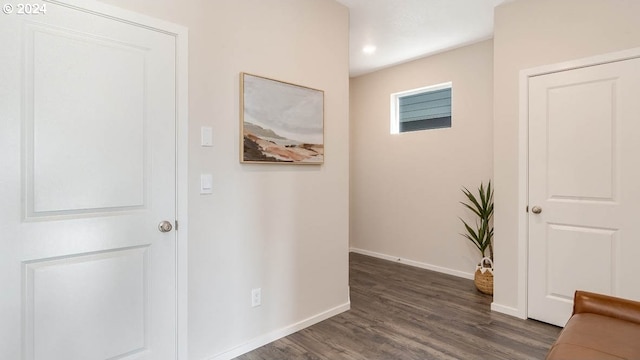 hallway featuring baseboards and dark wood-type flooring