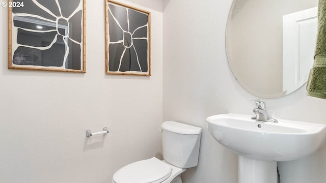 half bathroom featuring a sink and toilet