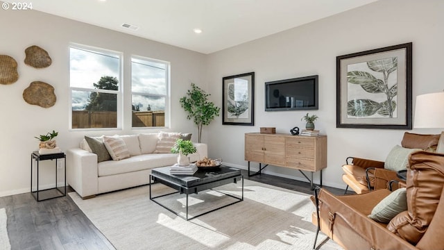 living area featuring recessed lighting, visible vents, baseboards, and wood finished floors