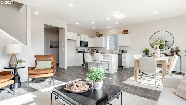 living room with baseboards, dark wood-type flooring, and recessed lighting