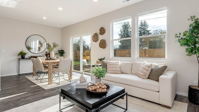 living area featuring visible vents, baseboards, wood finished floors, and recessed lighting