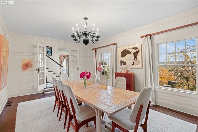 dining space with french doors, an inviting chandelier, visible vents, and crown molding