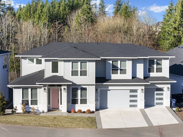 view of front facade with roof with shingles, concrete driveway, stone siding, and an attached garage