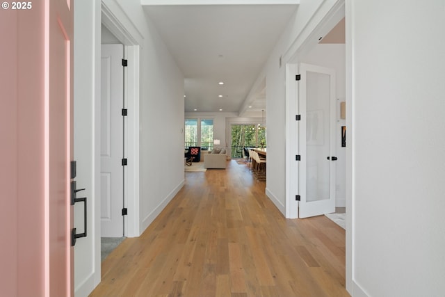 hallway with baseboards, recessed lighting, and light wood-type flooring