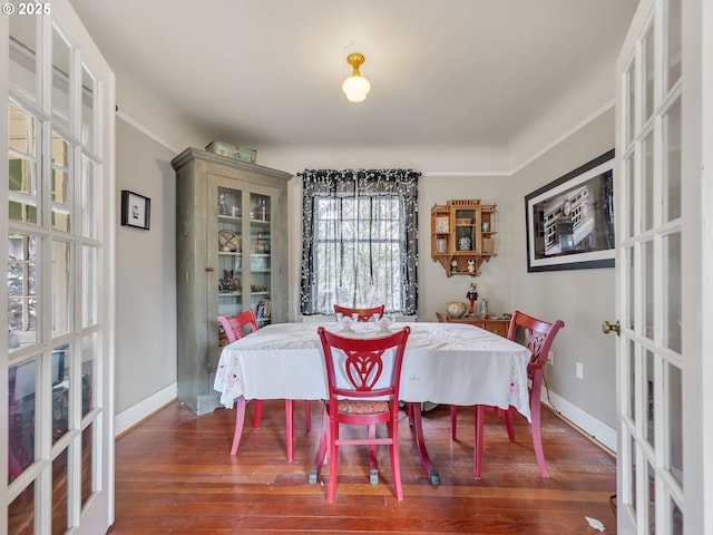 1078 Harrison Ave, Astoria, OR 97103 - dining area featuring french doors, wood finished floors, baseboards, and crown molding