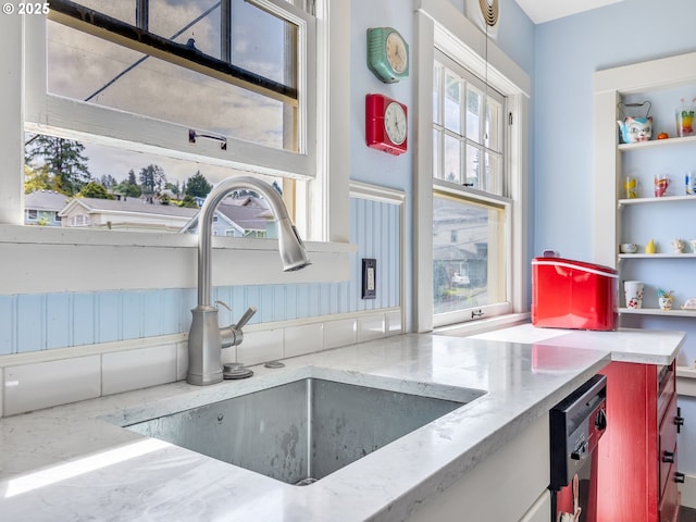 1078 Harrison Ave, Astoria, OR 97103 - kitchen featuring a sink, open shelves, dishwashing machine, and light stone counters