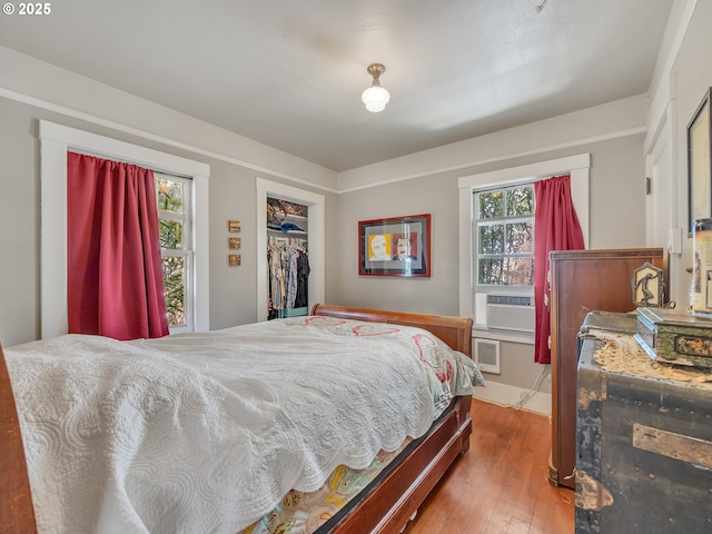 1078 Harrison Ave, Astoria, OR 97103 - bedroom featuring wood-type flooring, multiple windows, a closet, and cooling unit