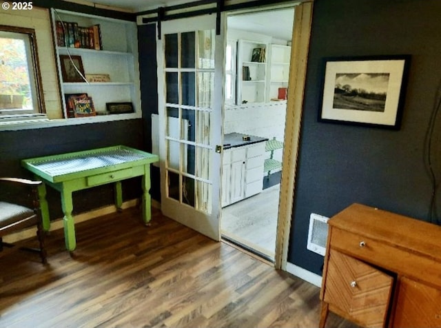 1078 Harrison Ave, Astoria, OR 97103 - doorway to outside featuring wood finished floors, a barn door, and baseboards