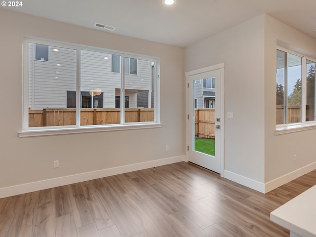 spare room with wood-type flooring and plenty of natural light