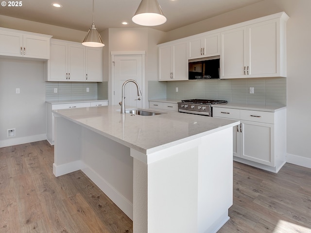 13863 SW Sabrina Ave, Tigard, OR 97140 - kitchen with stainless steel gas range, a sink, a center island with sink, white cabinets, and recessed lighting