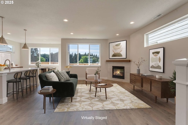 13863 SW Sabrina Ave, Tigard, OR 97140 - living area featuring a tile fireplace, recessed lighting, wood finished floors, and baseboards