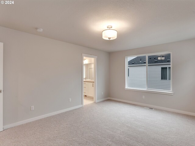 carpeted bedroom featuring connected bathroom