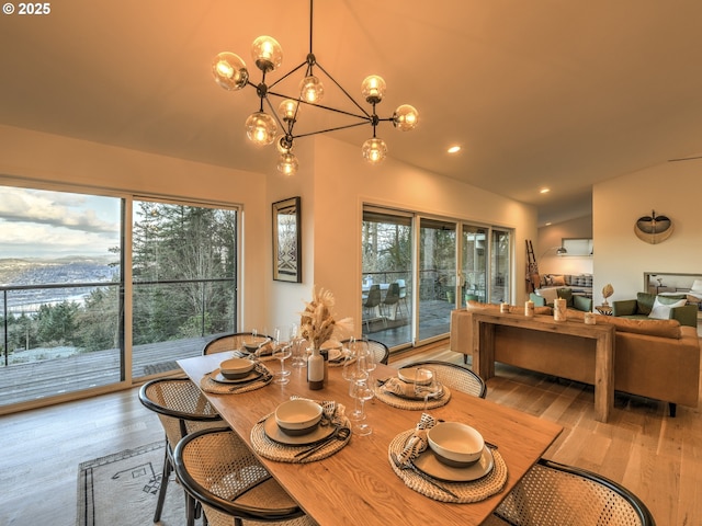 dining area with wood finished floors, a wealth of natural light, and an inviting chandelier