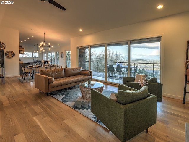 living room with baseboards, a chandelier, wood finished floors, and recessed lighting