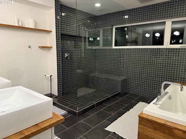 bathroom with tile patterned flooring, tiled shower, a garden tub, and a sink