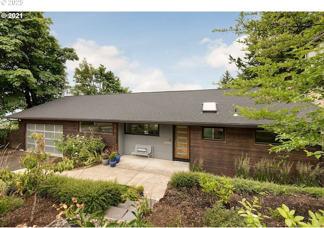 view of front of home with a garage and a shingled roof