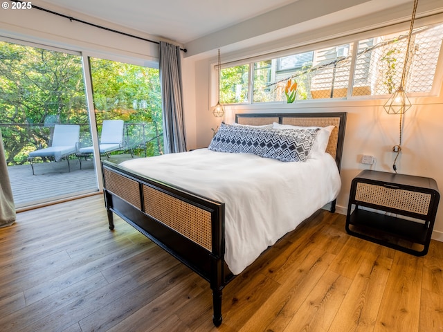 bedroom with access to outside and hardwood / wood-style floors