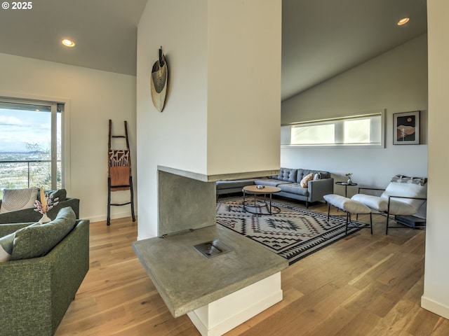 living room with high vaulted ceiling, recessed lighting, baseboards, and wood finished floors